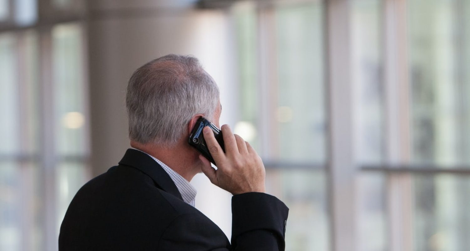 mann i dress snakker i en mobiltelefon